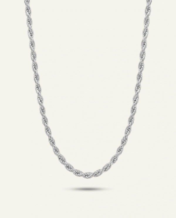 A polished silver-toned twisted rope chain necklace hanging in a classic U-shape with a subtle shadow beneath, set against a light cream background.