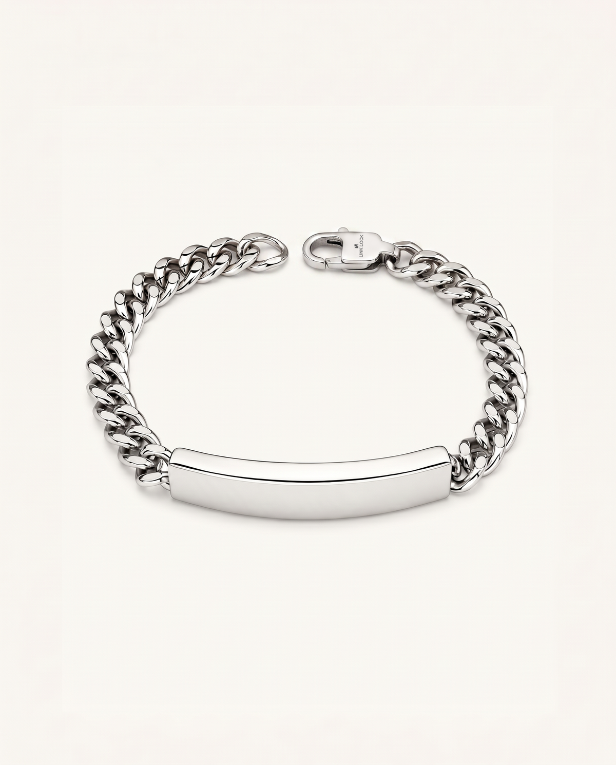 A silver-tone chain link bracelet with a smooth, polished ID bar in the center, displayed on a clean off-white background.