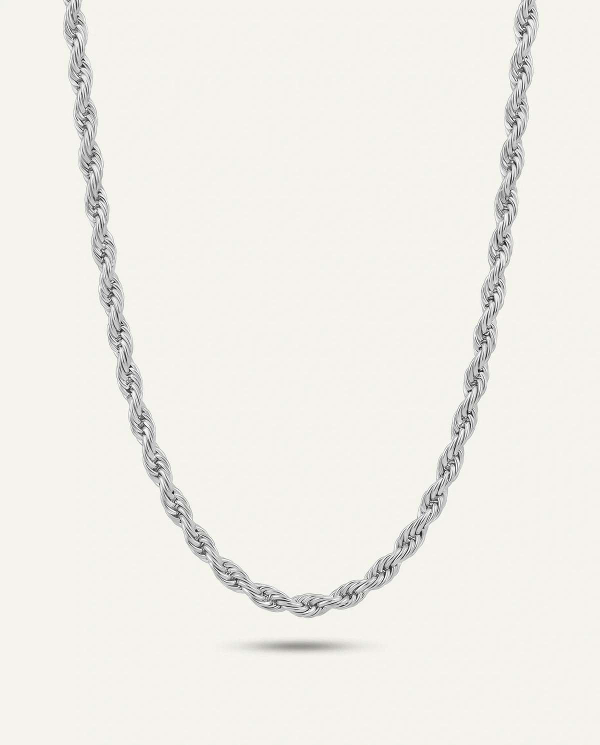 A silver-toned braided chain necklace with a polished finish, displayed in a U-shape against a clean white background with a subtle reflection below.