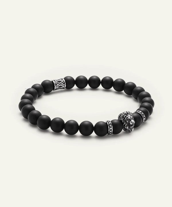 Black beaded bracelet with metal charms on a white background