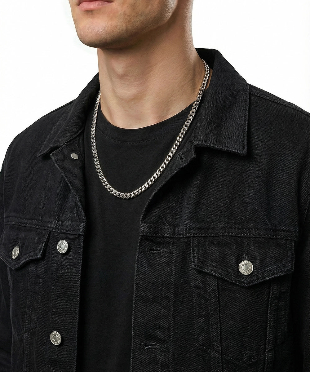 men's silver-toned Cuban chain necklace on model wearing black denim jacket