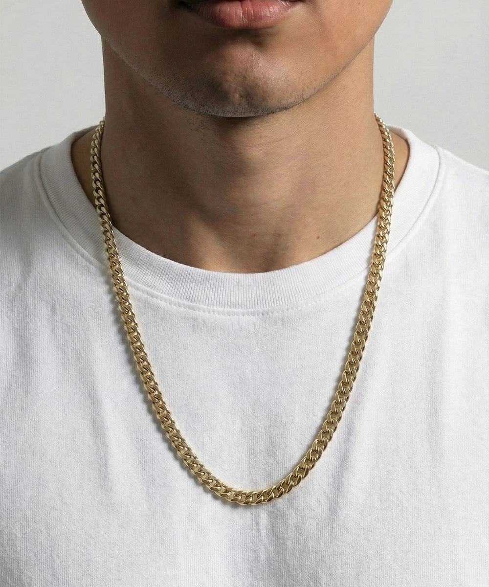 men's 24-inch gold-toned Cuban chain necklace on model wearing white t-shirt