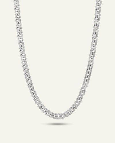 A silver-toned curb chain necklace displayed in a curved U-shape against a light off-white background. - alternate view