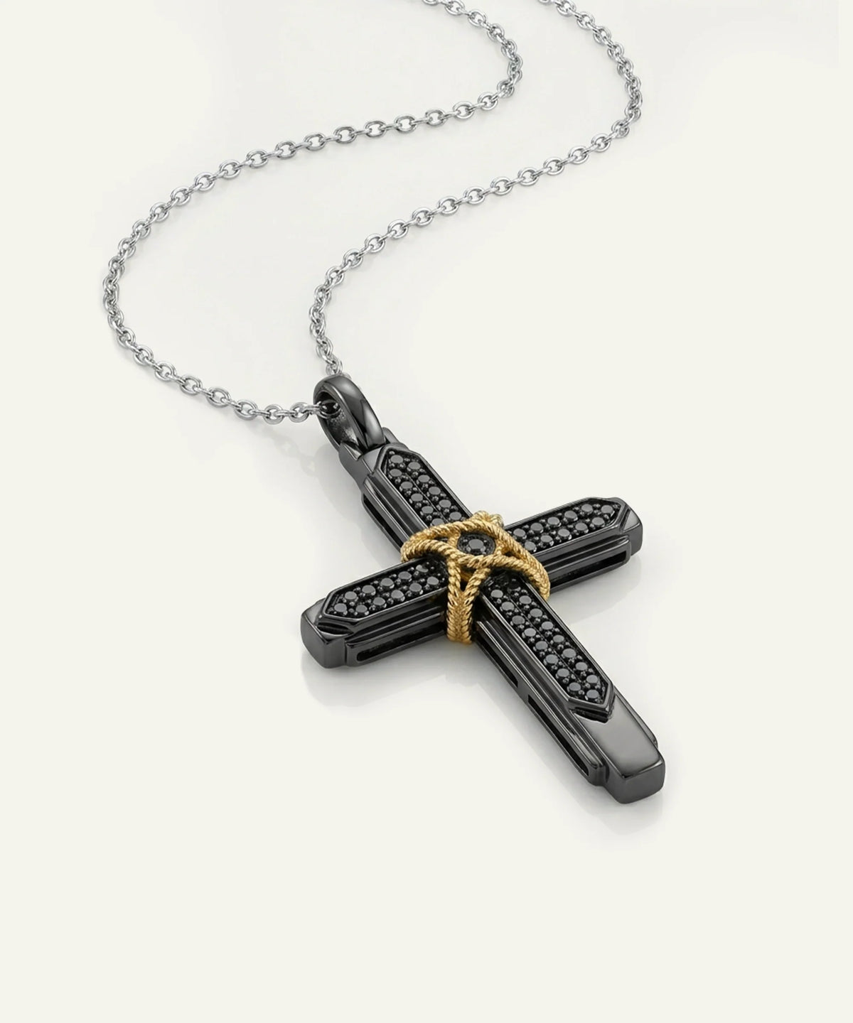 A black cross pendant necklace with a textured, diamond-like pattern and a gold-toned star detail at the center, suspended from a silver-toned chain on a light cream background.