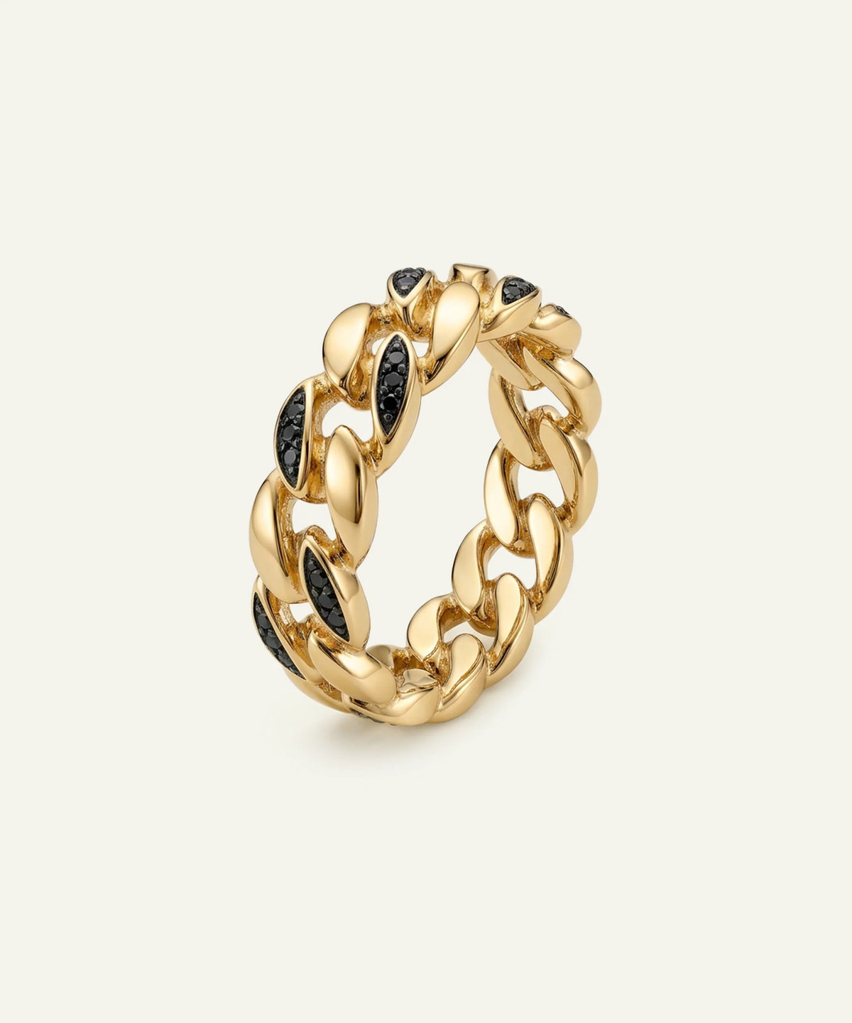 A men's yellow gold Cuban link band ring set with black round-cut gemstones on a light cream background.
