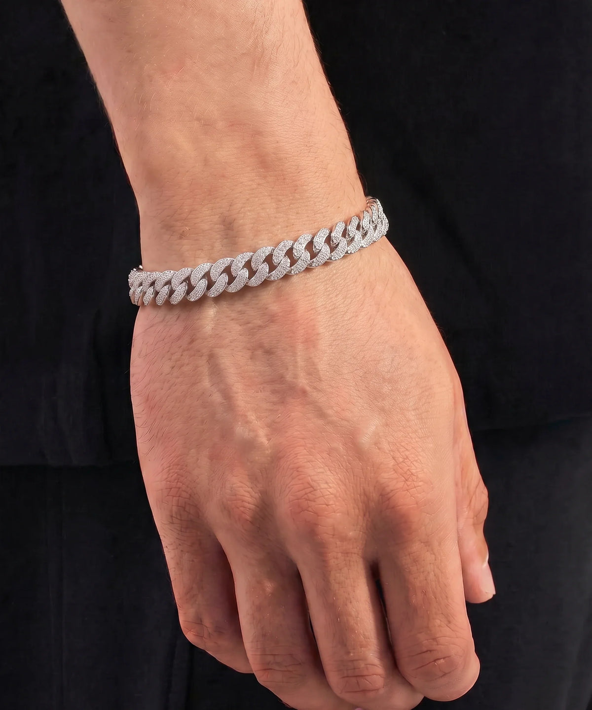 Close-up of a man's wrist wearing a diamond Cuban link bracelet